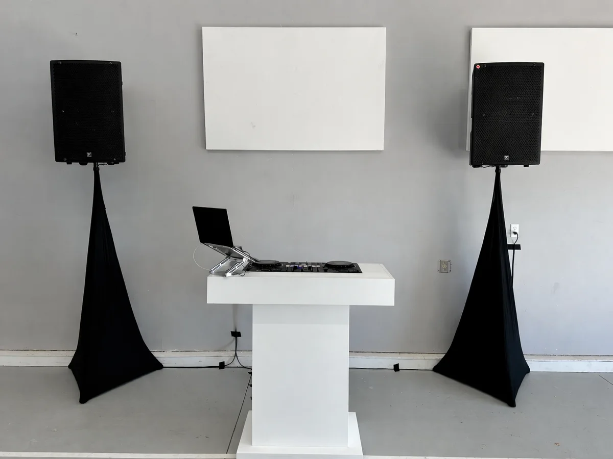 Clean corporate DJ setup with speakers and booth
